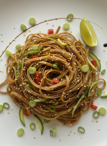 Noodles with vegetables on a white plate